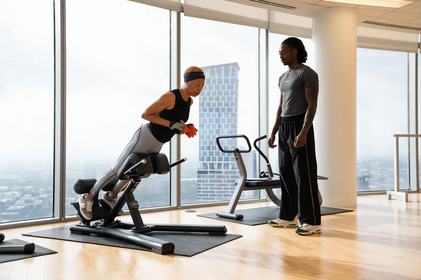 A one-on-one session in a residence gym with floor-to-ceiling windows